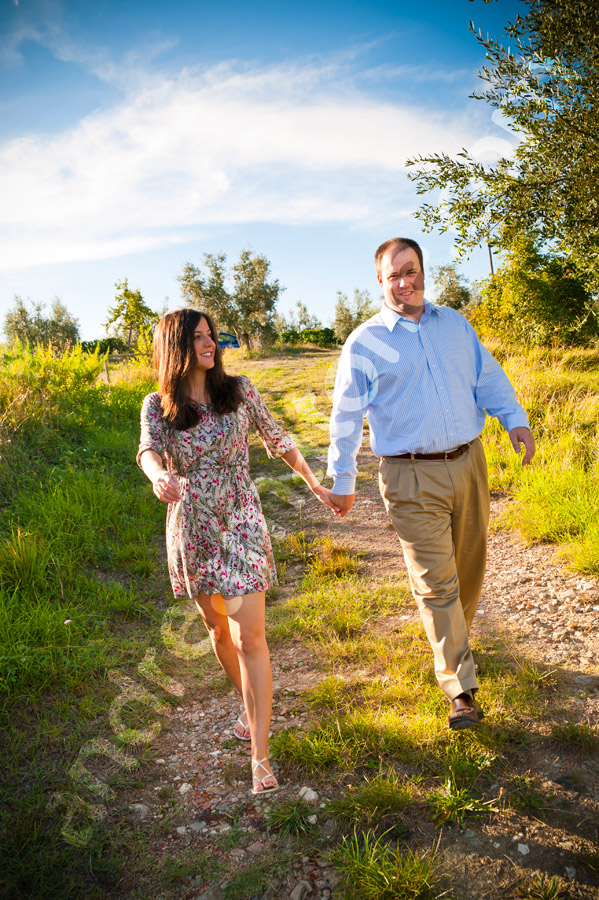 Couple walking hand in hand through the Tuscan countryside. Tuscany engagement session 