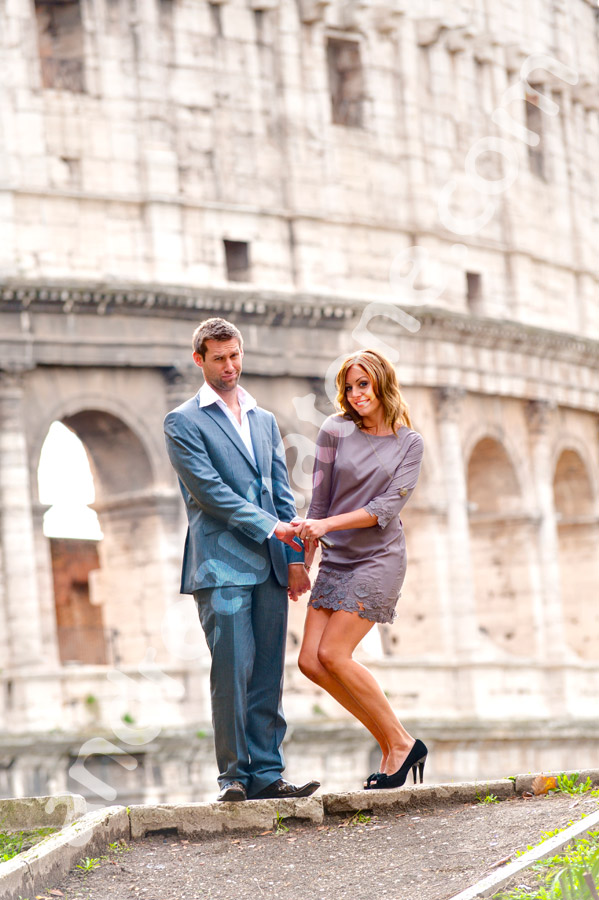 Man and woman in front of the Roman Colosseum. Posing pictures during an engagement session.