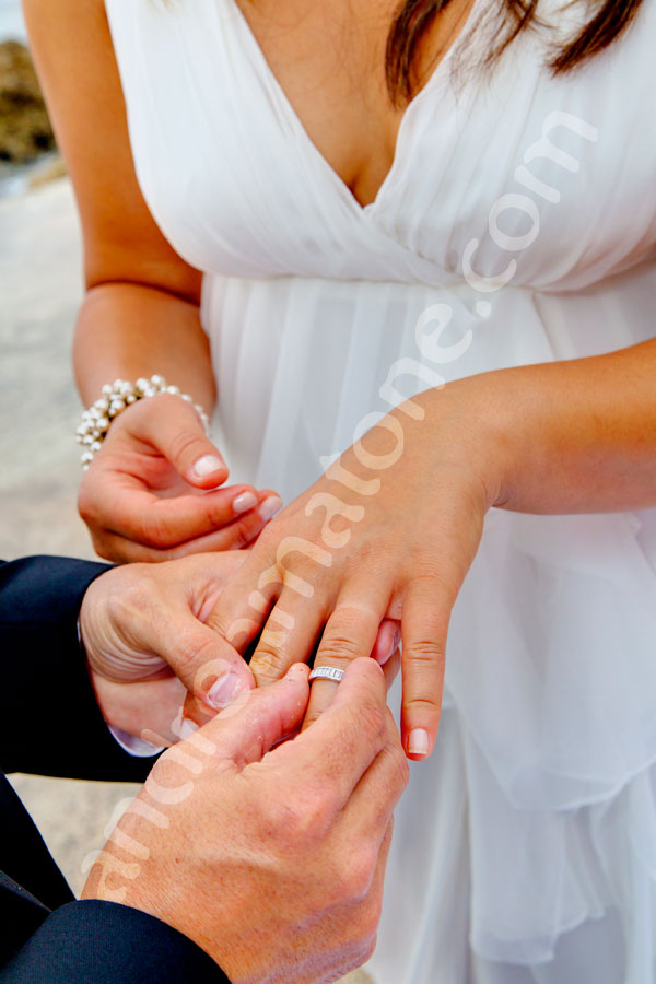 Putting the ring on a bride's hand during a private wedding ceremony