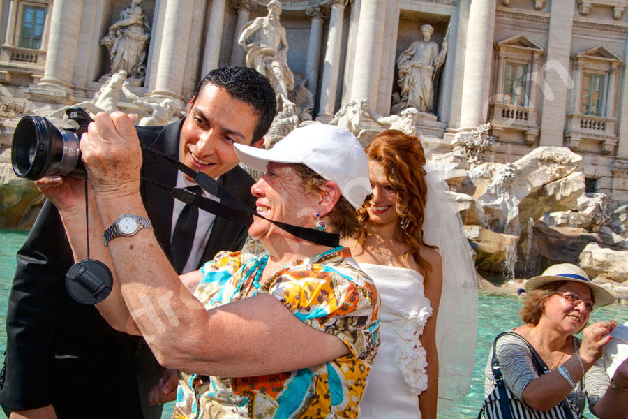 Tourist photographer taking a picture of the wedding bride and groom