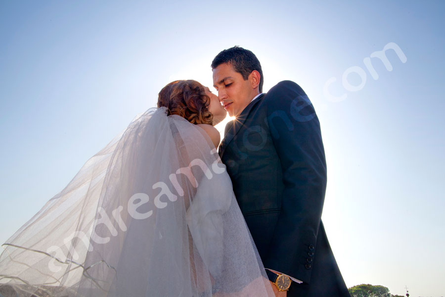 Bride and groom kissing in blue sky 