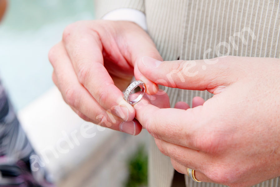 The groom holding the wedding ring 