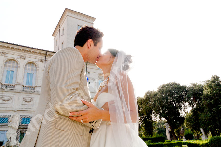 Newlyweds kissing Parco Villa Borghese