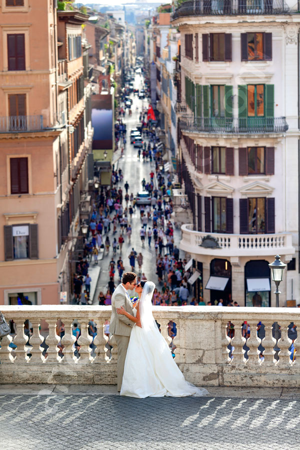 Kissing after the wedding in Piazza di Spagna with the view of Via Condotti in the far distance