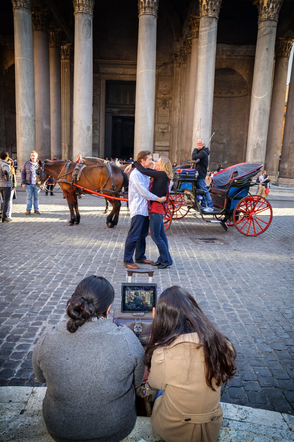 Couple romantically in love. Pantheon. While tourists watch tv waiting.