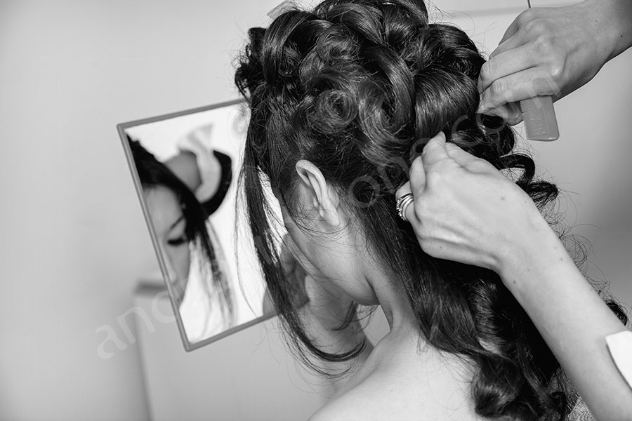 Bridal party getting hairstyle done during preparation 