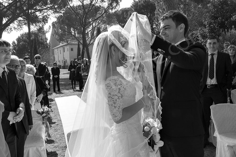 The groom taking off the the bride's veil 