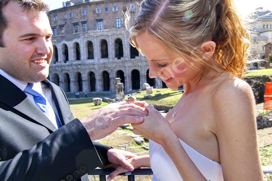 Bride looking at the small snail resting on the groom's hand 