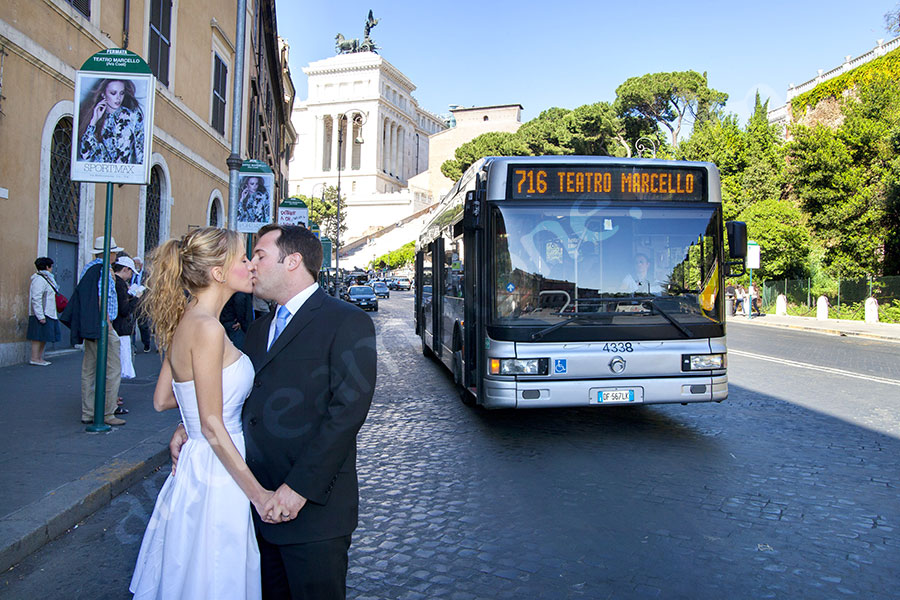 Couple kissing in love in front of a bus Teatro Marcello