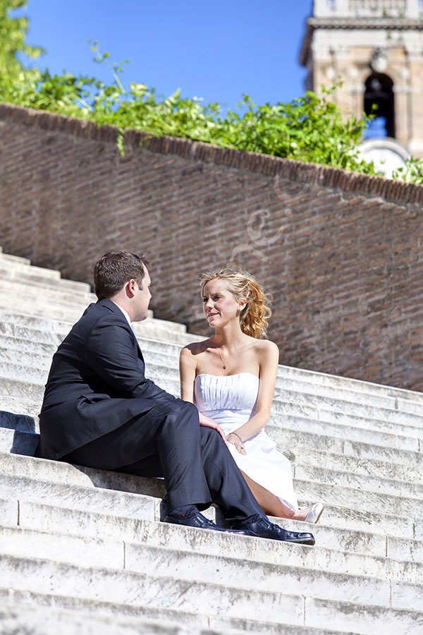 Bride and groom sitting down on stairs by the Capidoglio piazza