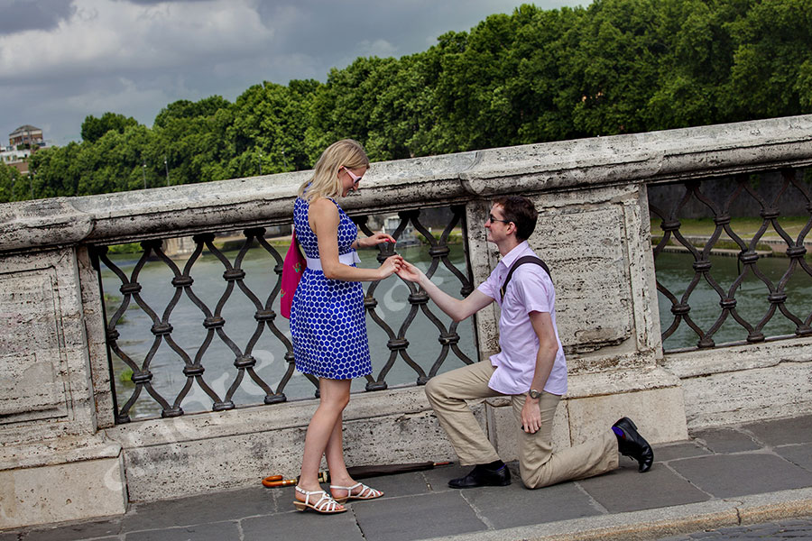 The secret proposal asked on Castel Sant'Angelo bridge. Surprise wedding proposal photography in Rome.