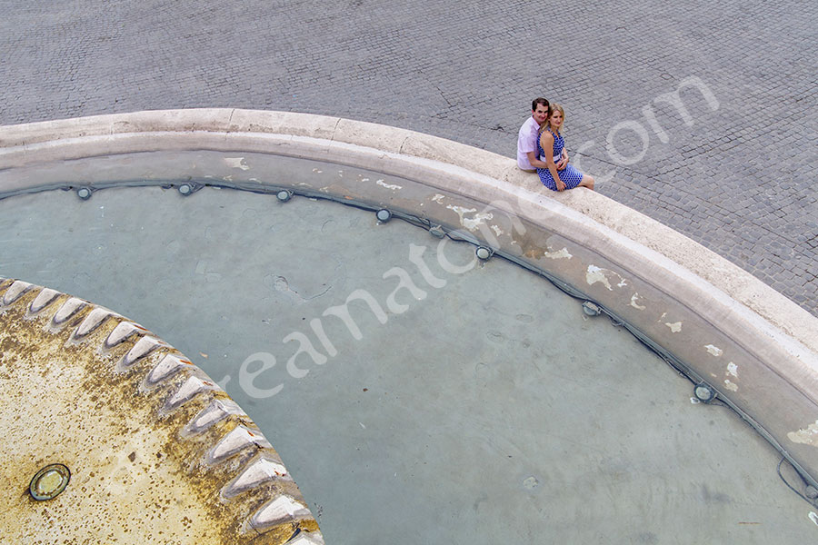 Sitting by a water fountain and looking up in Piazza del Popolo