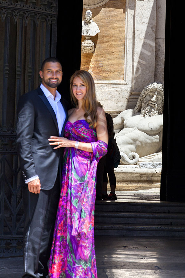 Couple posing in front of a statue during a photography session in Rome