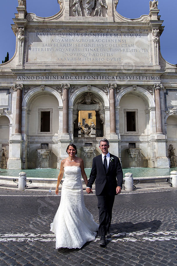 Wedding couple walking in front of the Gianicolo water fountain in Rome