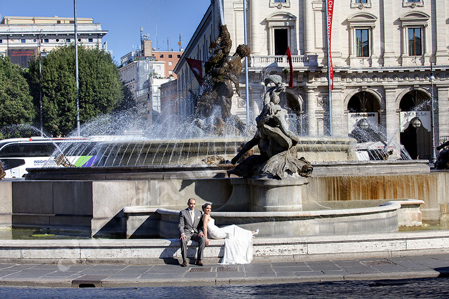 Newlyweds sitting down next to an Italian water fountain