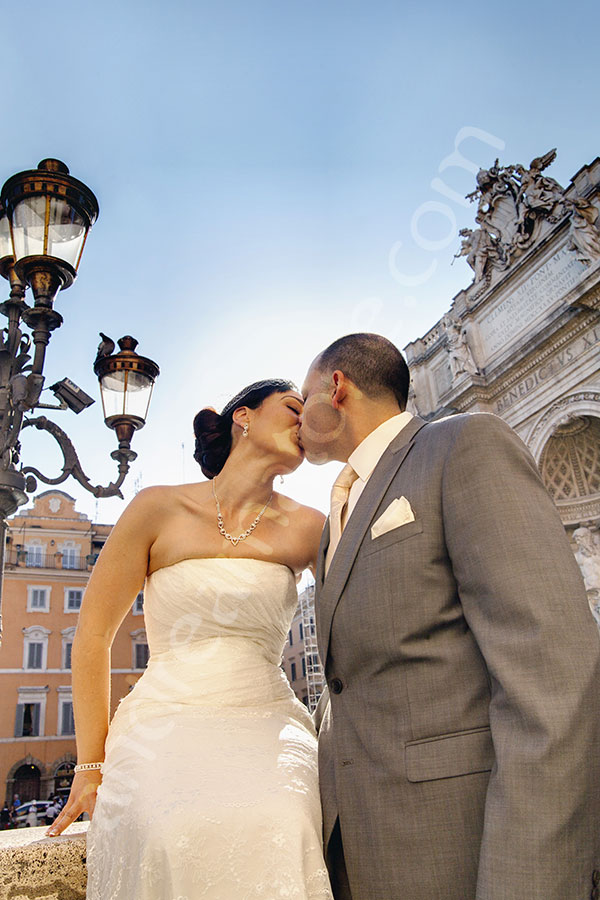 Photo session including a wedding couple kissing by the Trevi fountain.