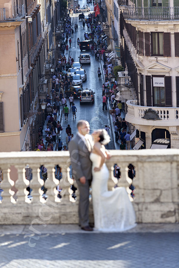 Couple pat the balcony of the Spanish steps overlooking Via del Corso