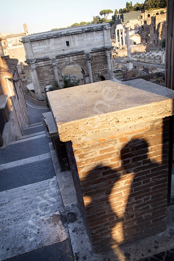 A kissing shadow casting on a roman wall.