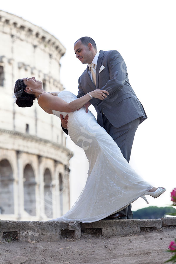 Groom dipping bride over in front of the Colosseum