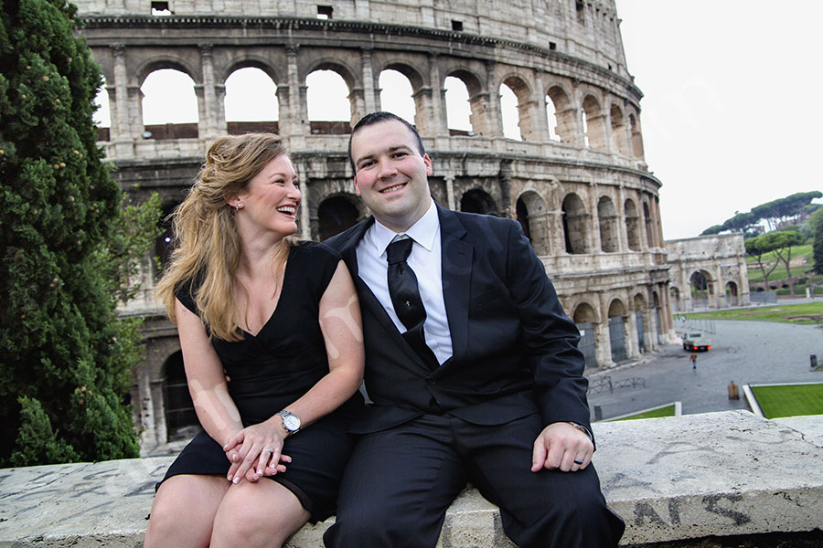 On a beautiful engagement style session. Sitting on a marble wall. Coliseum. Honeymoon Photographer Rome.