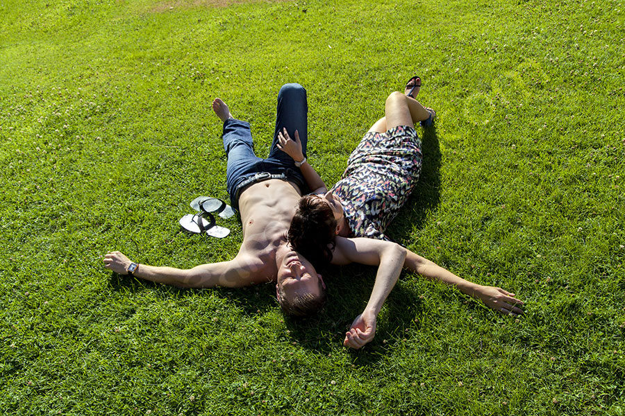 Couple relaxing on green grass Villa Borghese Rome Italy. Photographer. 