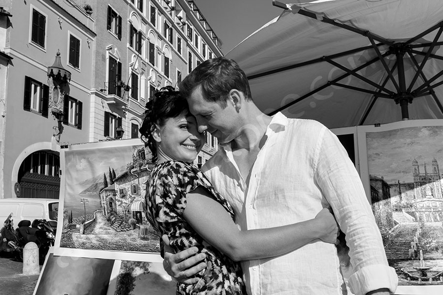 Man and woman up on Trinita' dei Monti next to paintings.