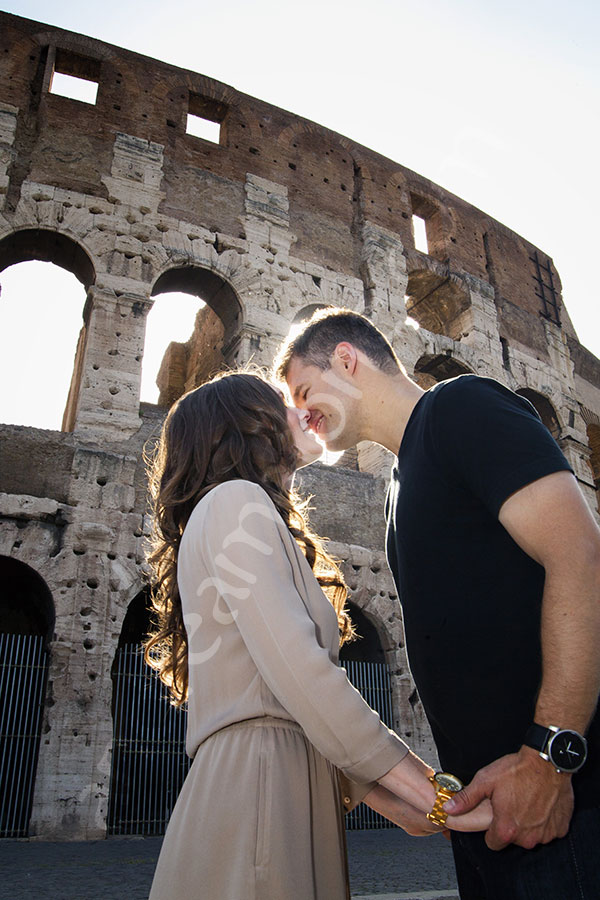 A romantic love story. Close up picture of a couple kissing in front of the Coliseum