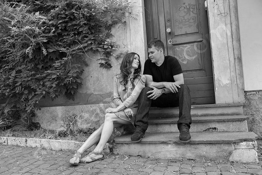 Sitting down and hanging out by the door steps. In a courtyard.