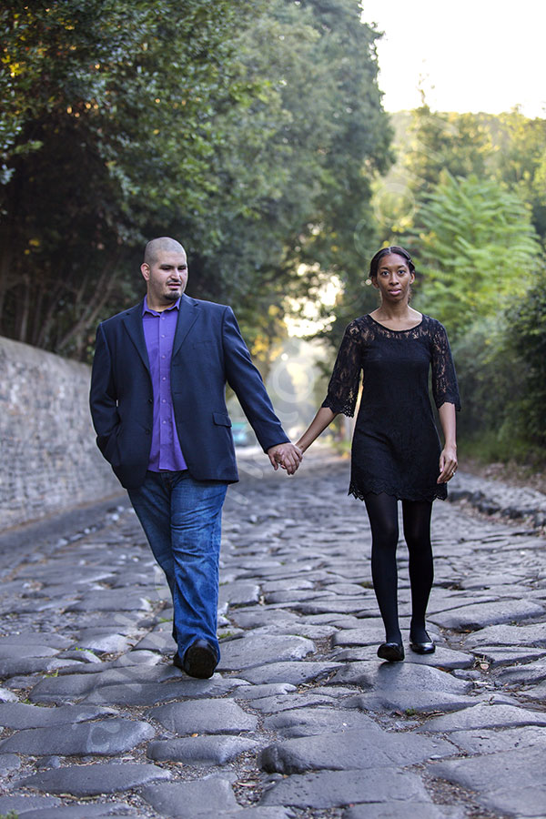 Walking together holding hands on the ancient Appia road in downtown Italy