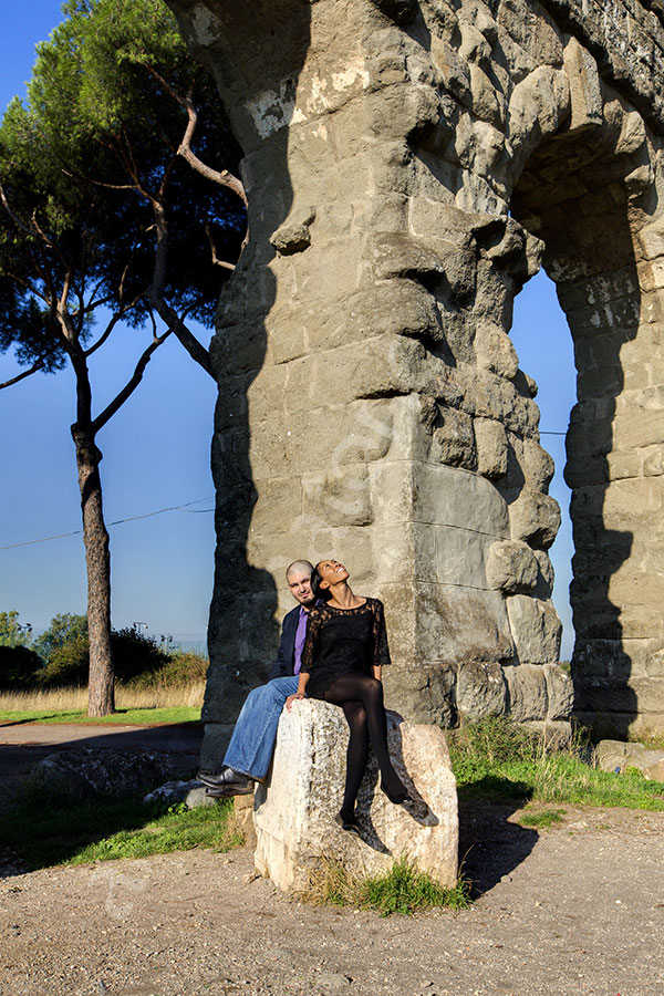 Engaged looking up at the plane below an old ancient aqueduct in a park