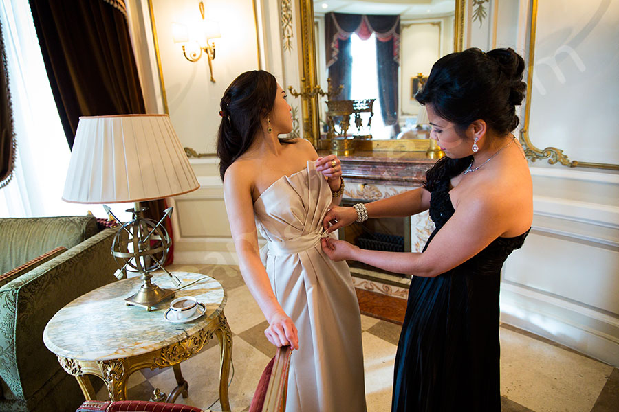 Bride helping bridesmaid with her dress during the preparation in Rome