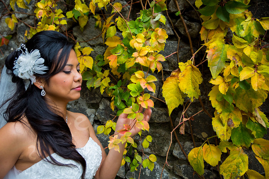 Bride photographed next to colorful ivy leaves 