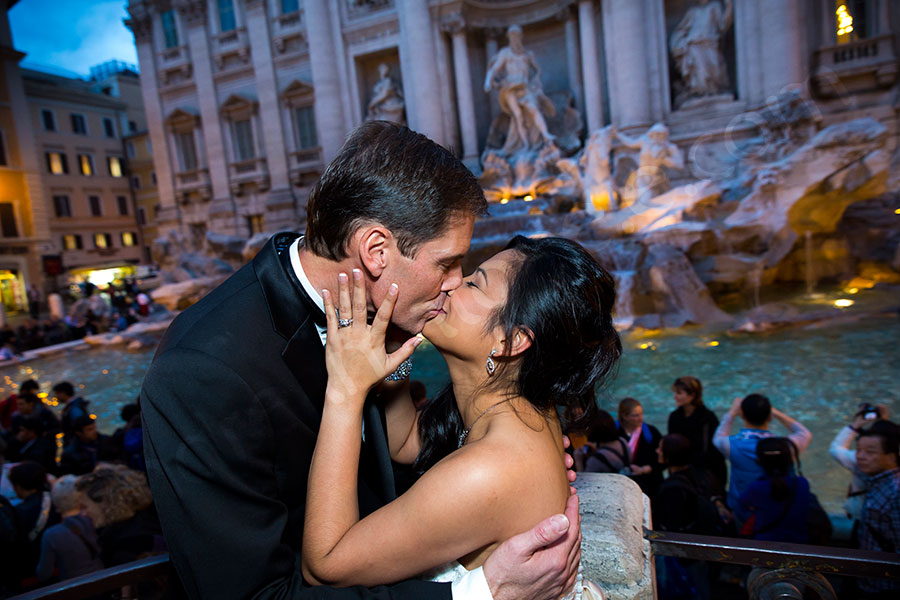 Couple just married kissing at the Trevi fountain evening time