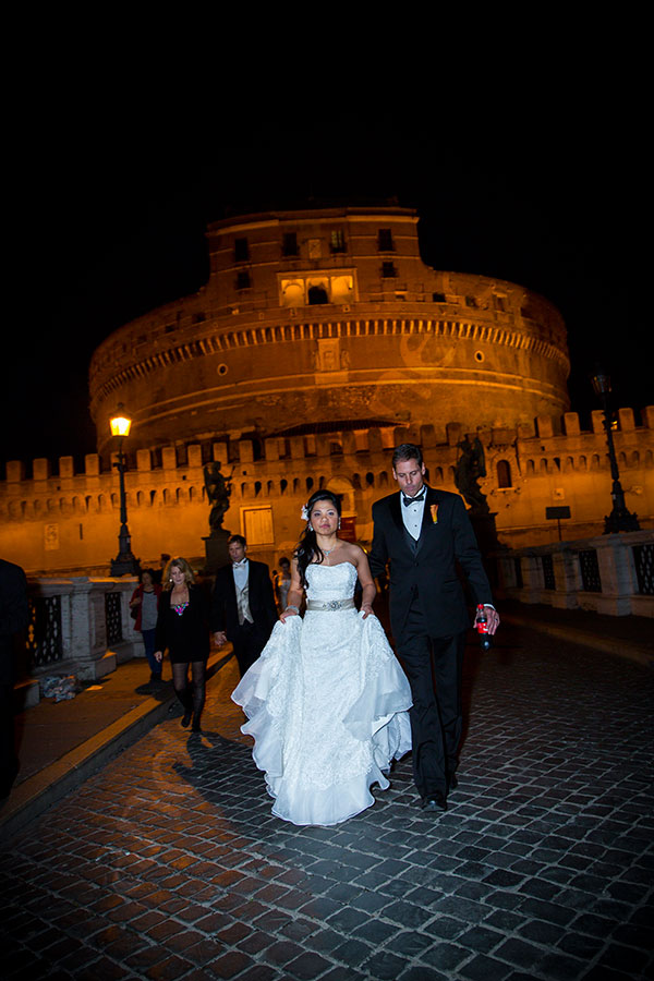 Just married couple walking on Ponte Castel Sant'Angelo in Rome Italy