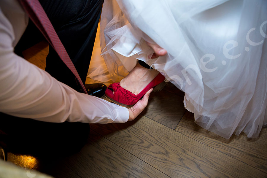 Groom putting on the shoes of the bride 