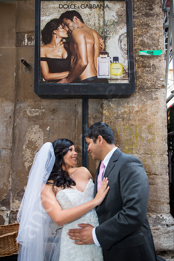 Couple posing in front of a street poster in the Italian streets.