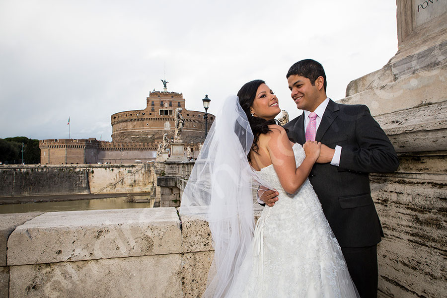 Castel Sant'Angelo with the bride and groom posing in front of the exterior facade.