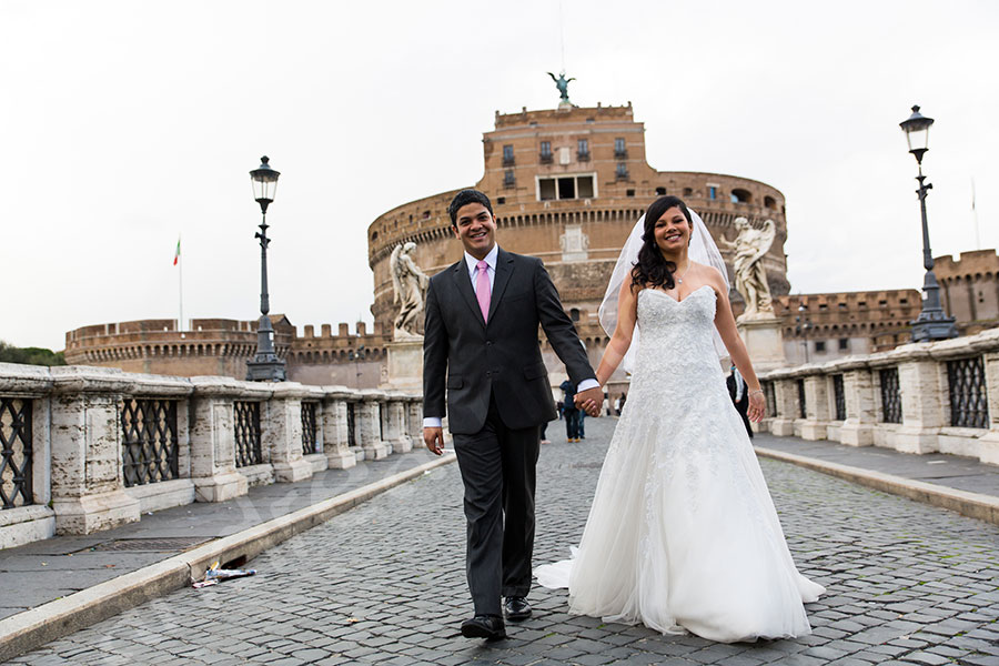 Walking hand in hand on Castel Sant'Angelo bridge.