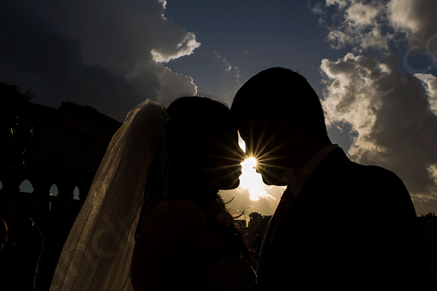 Silhouette couple kissing with the sun in between 