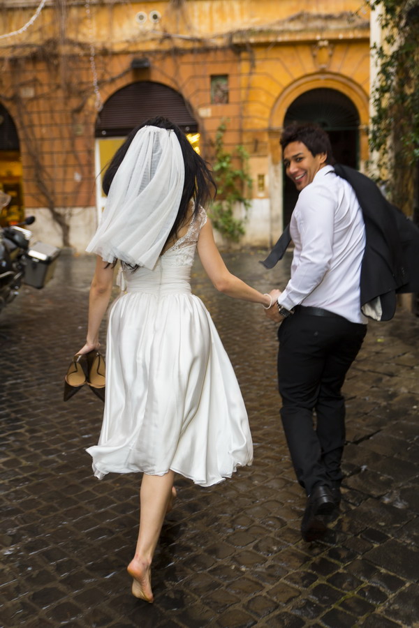 Bride and groom running during a wedding photo shoot on Via Margutta in Rome color version