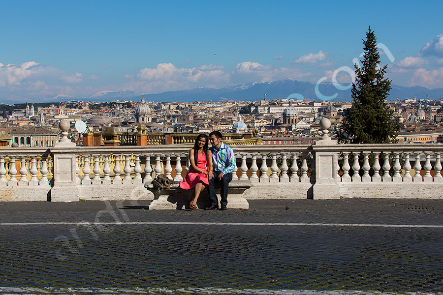Couple photographed with the beautiful view of the city of Rome in the far distance 