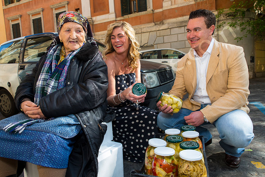 Couple having fun talking with an old lady selling hearty chokes