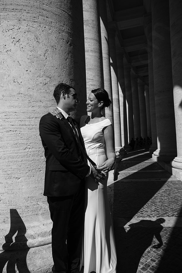 Couple posing for a picture at the Vatican under the stunning columns.