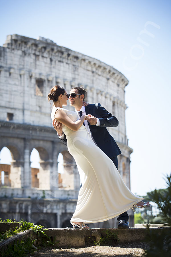 Newlyweds at the Roman Colosseum on a romantic pose.