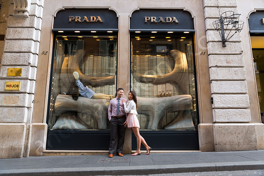 Engagement photographer picture posing in front of the Prada showcase