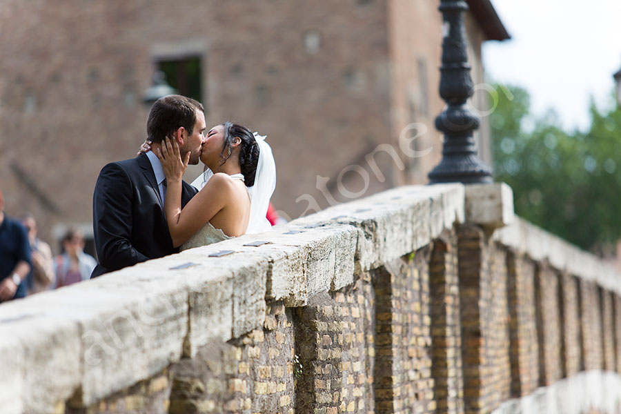 Newlyweds kissing on Tiber island bridge