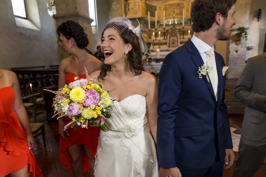 Happy newlyweds exit Church Castello di Spaltenna in Gaiole in Chianti