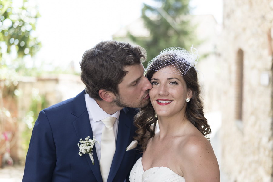 Newlyweds kissing in the streets of an old town in Italy