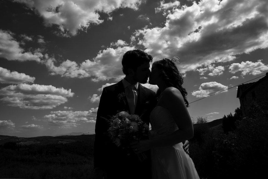 Black and white version of couple under fluffy clouds