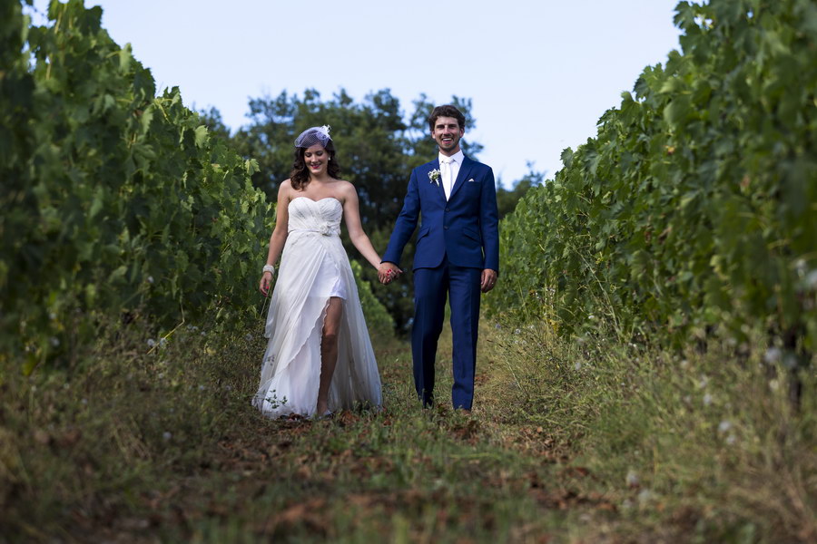 Picture in focus photo as newlyweds walk in a vineyard in Italy